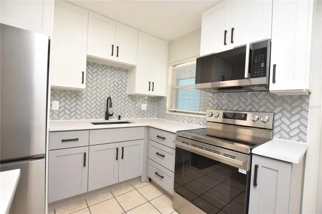 a kitchen with white cabinets and stainless steel appliances
