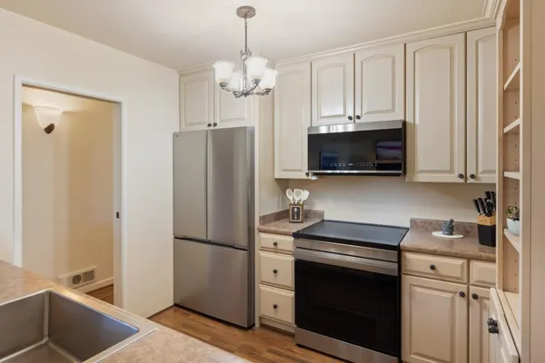 a kitchen with stainless steel appliances a refrigerator sink and microwave
