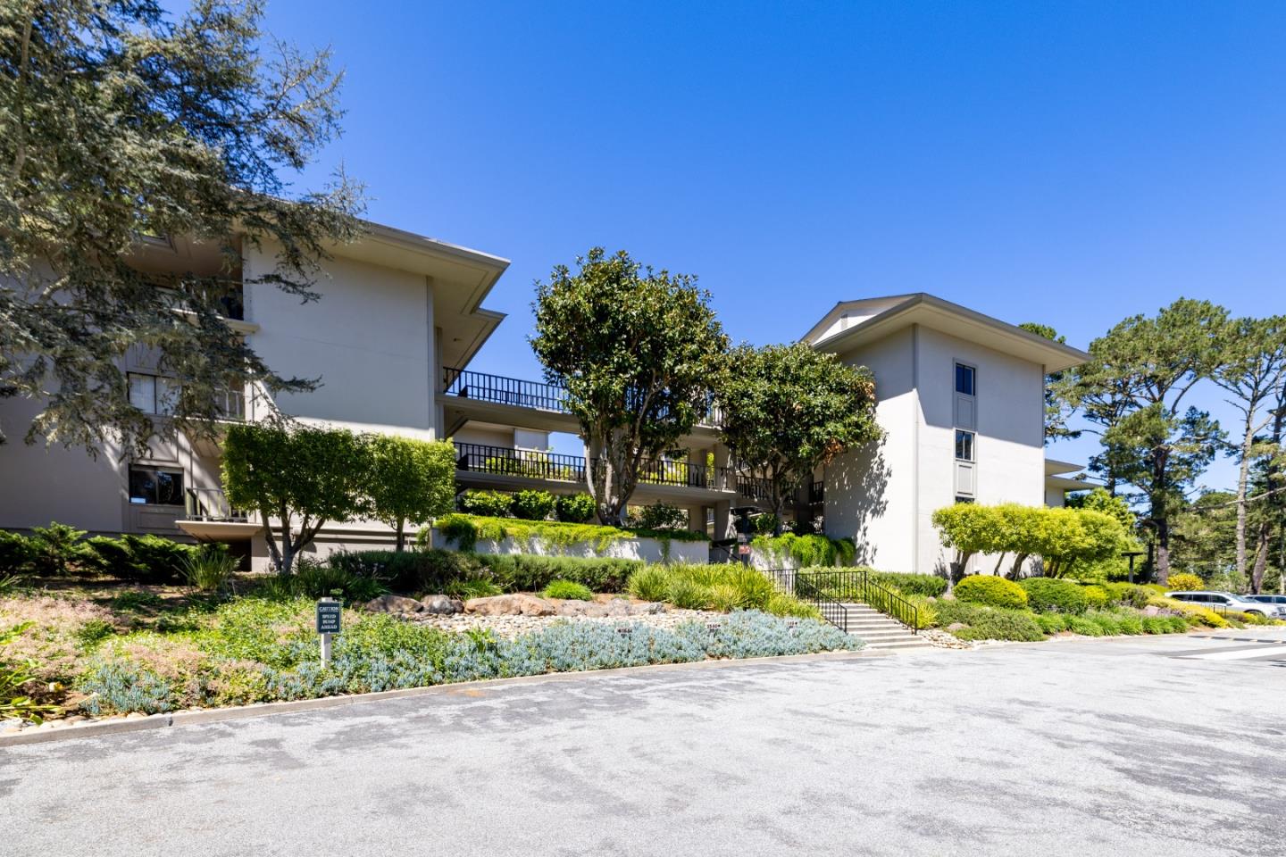 4 Ocean Pines Lane Pebble Beach, CA 93953 - Photo 37 of 49 a front view of a house with a garden and plants