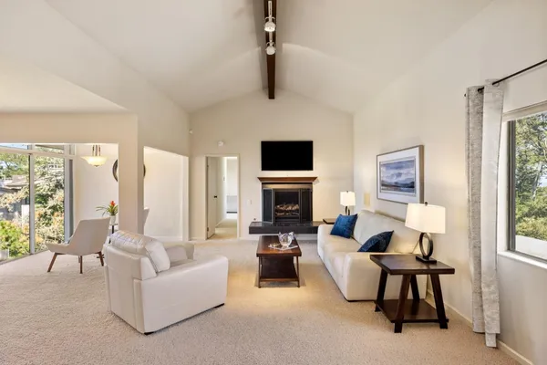 a living room with furniture a fireplace and a flat screen tv