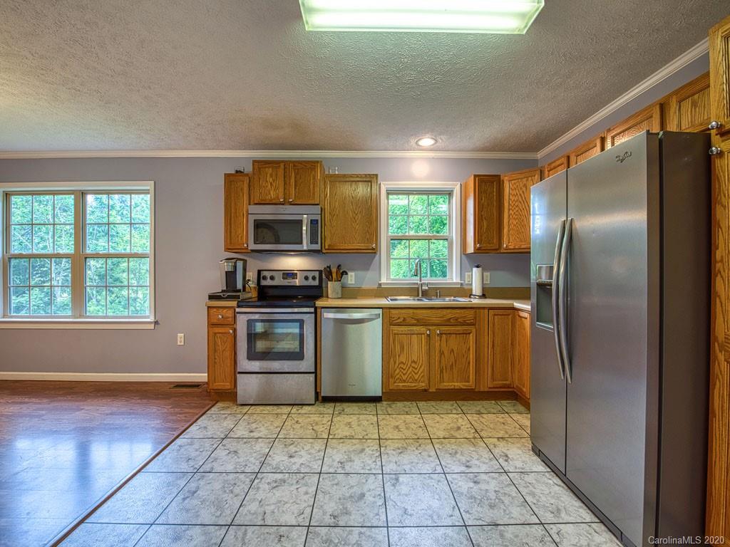 81 Relief Loop Clyde, NC 28721 - Photo 16 of 39 a kitchen with a refrigerator a stove top oven and a window