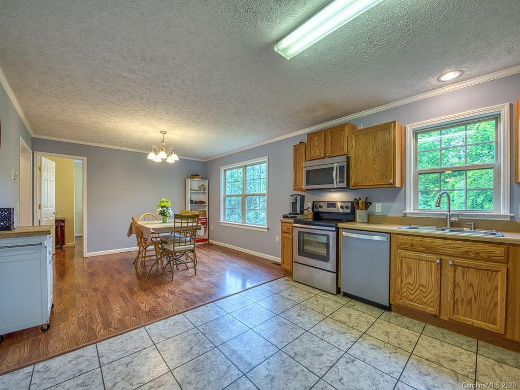81 Relief Loop Clyde, NC 28721 - Photo 17 of 39 a kitchen with granite countertop a stove top oven dining table and chairs