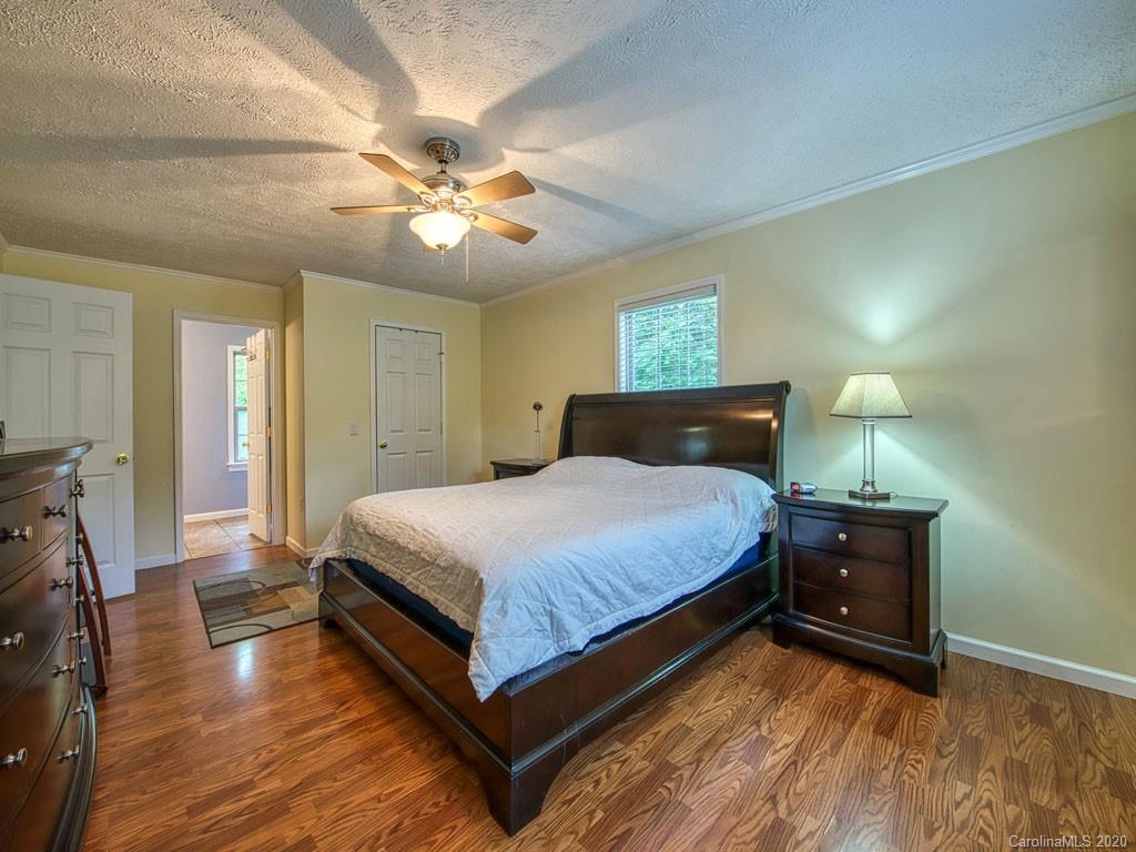 81 Relief Loop Clyde, NC 28721 - Photo 23 of 39 a bedroom with a bed and a chandelier