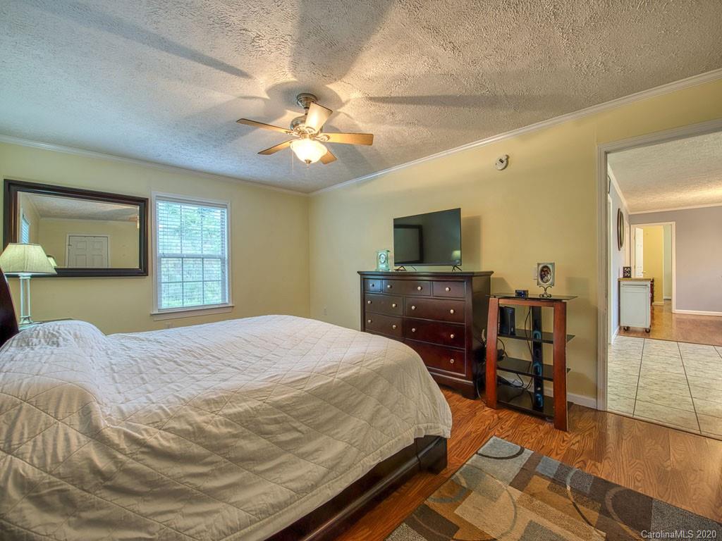 81 Relief Loop Clyde, NC 28721 - Photo 24 of 39 a bedroom with a bed and a chandelier