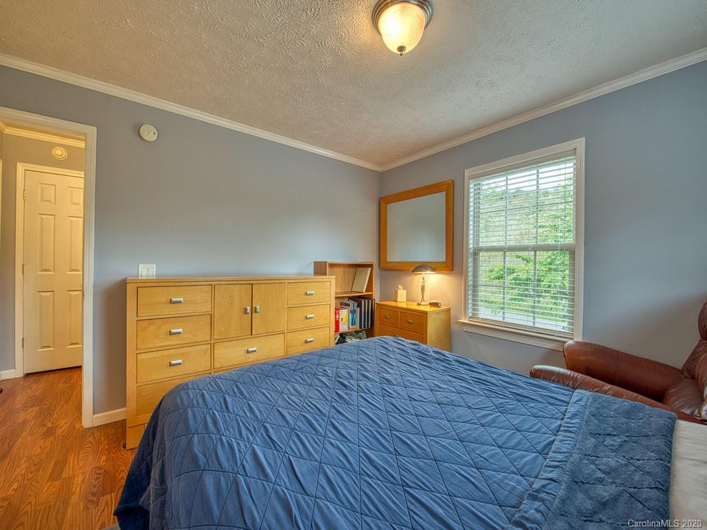 81 Relief Loop Clyde, NC 28721 - Photo 29 of 39 a bedroom with a bed and a dresser next to a window