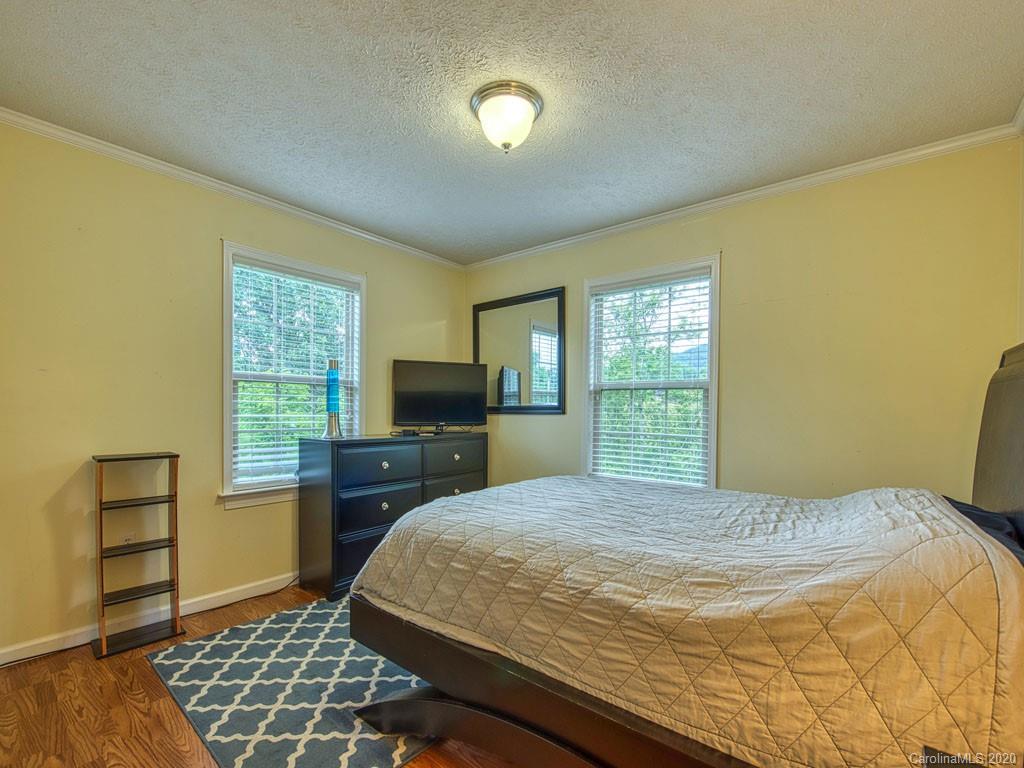 81 Relief Loop Clyde, NC 28721 - Photo 32 of 39 a bedroom with a bed and wooden floor