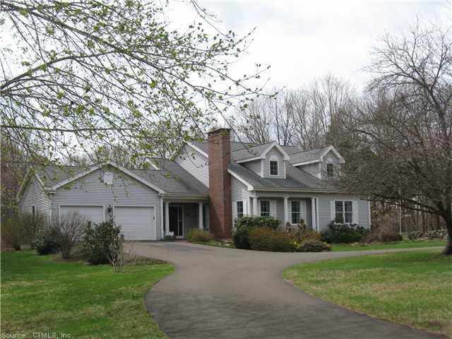 a front view of a house with a garden and trees
