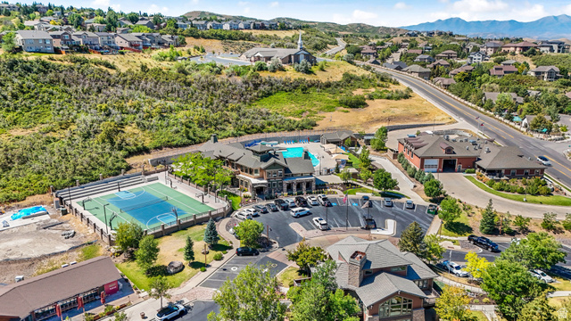 14771 Haddington Road Draper, UT 84020 - Photo 43 of 44 Expansive recreation area featuring a multi-sport court with spectator seating, a large outdoor swimming pool, and a clubhouse with stone and timber accents