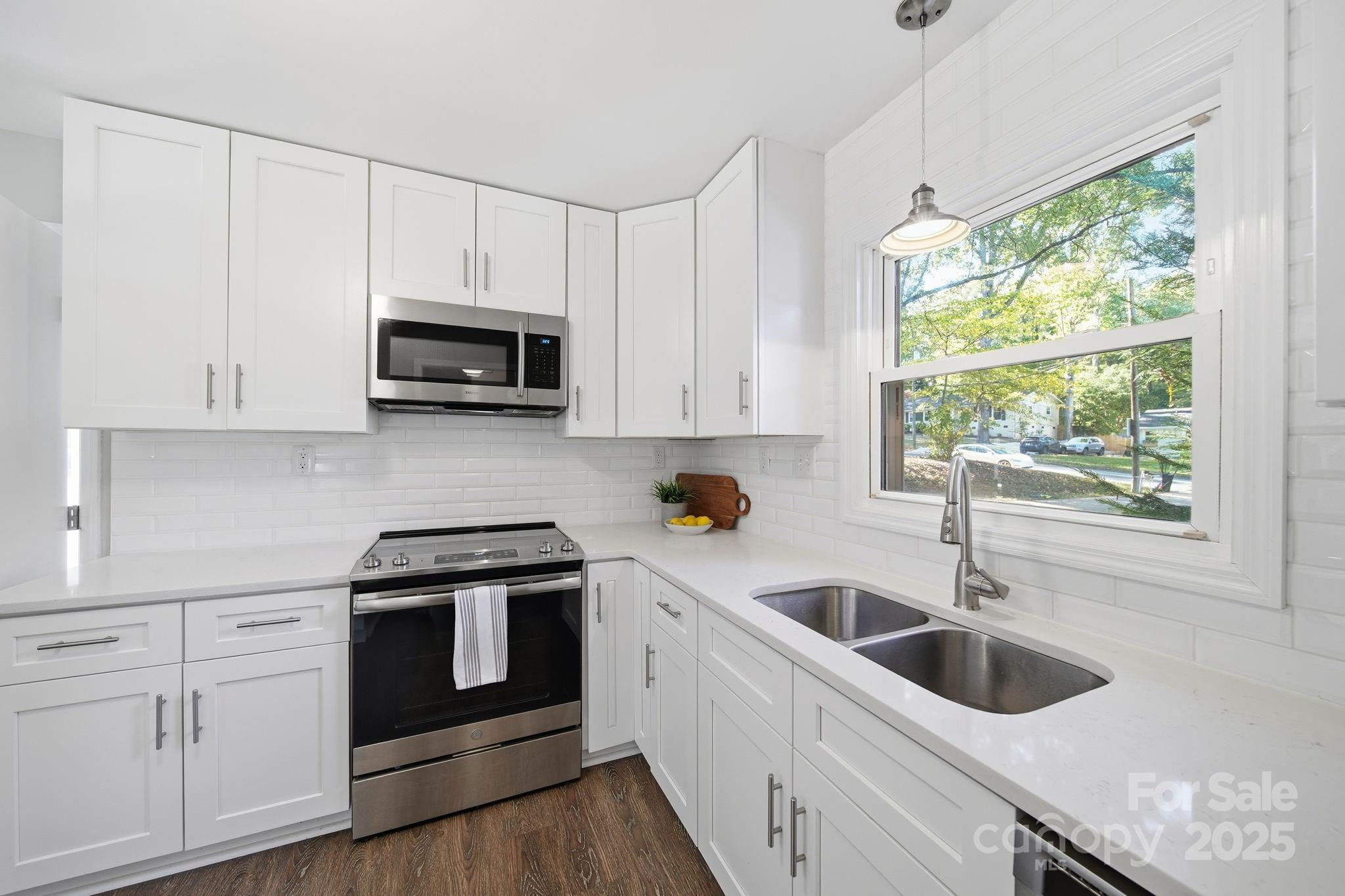 5631 Londonderry Road Charlotte, NC 28210 - Photo 13 of 32 a kitchen with granite countertop white cabinets a sink and a stove with wooden floor