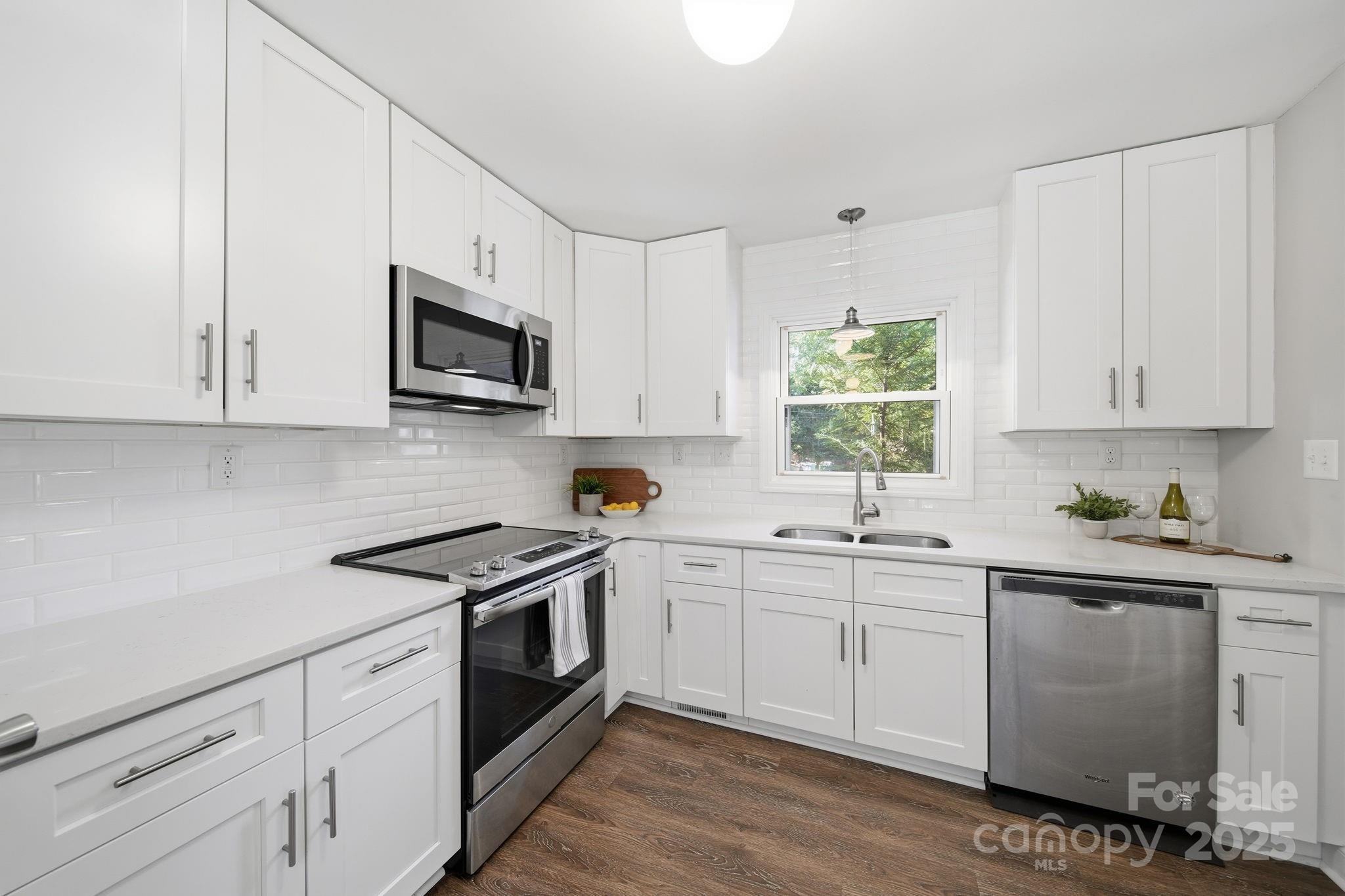 5631 Londonderry Road Charlotte, NC 28210 - Photo 9 of 32 a kitchen with stainless steel appliances granite countertop white cabinets a sink a stove a window and white cabinets