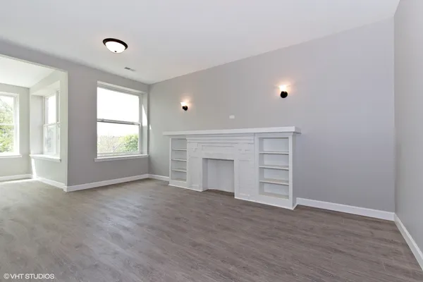 a view of an empty room with a window and fireplace
