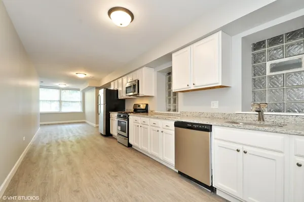 a kitchen with granite countertop white cabinets and white appliances
