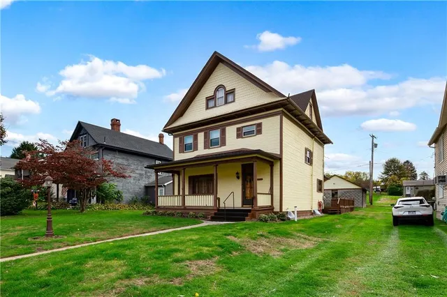a view of a big house with a big yard and large trees