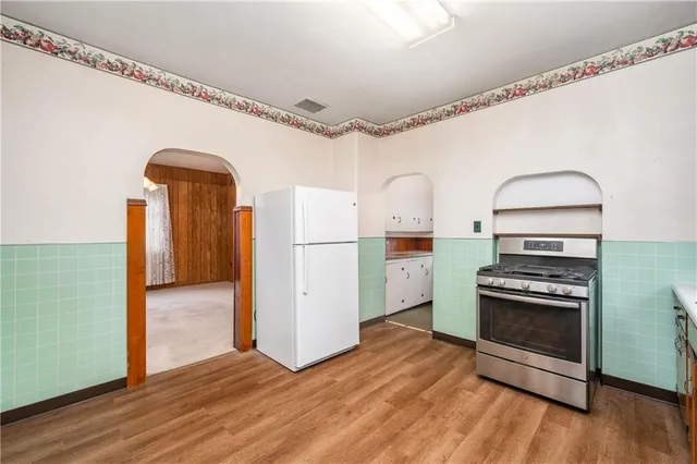 a kitchen with a refrigerator and a stove top oven