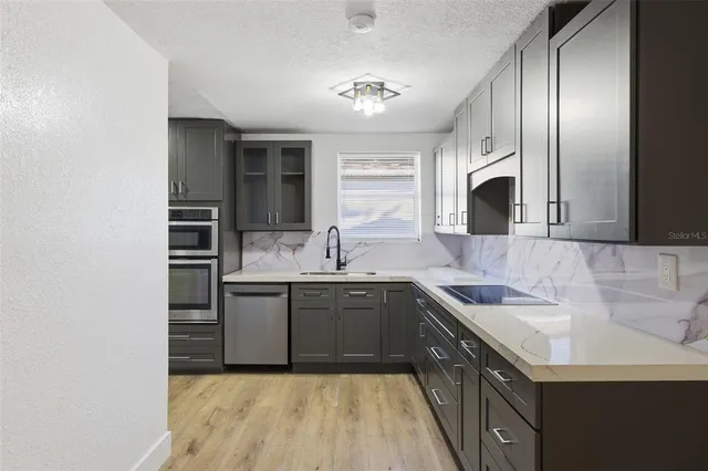 a kitchen with stainless steel appliances a refrigerator and microwave