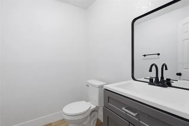 an empty room with wooden floor chandelier fan and windows