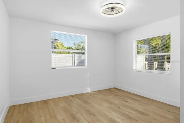 a view of empty room with wooden floor