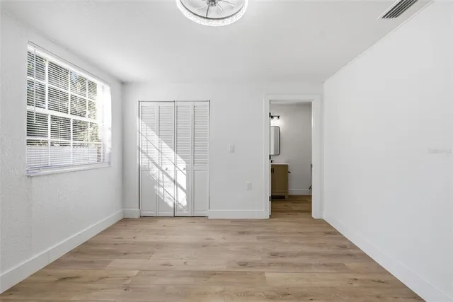 a view of empty room with wooden floor and window