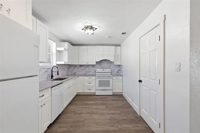 an aerial view of residential houses with outdoor space and trees