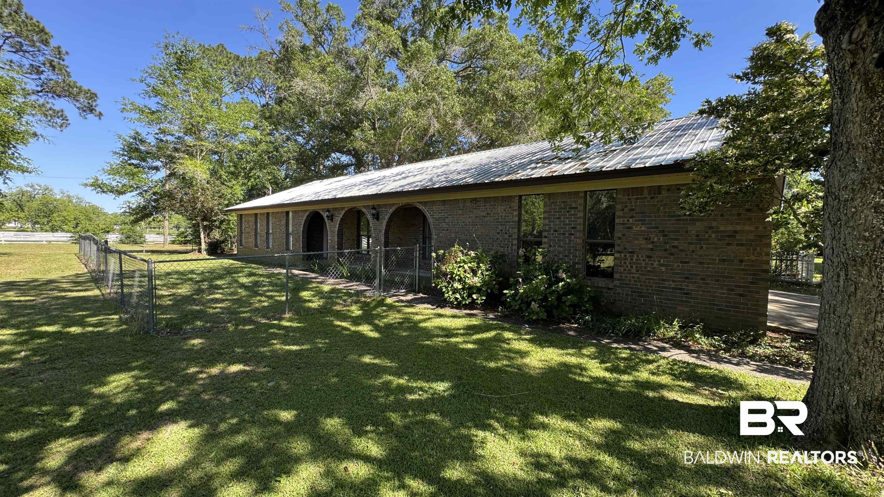 33370 Highway 98 Lillian, AL 36549 - Photo 7 of 58 Brick-clad exterior featuring a metal roof, an arched portico, and multiple windows