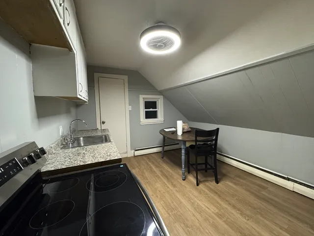 a kitchen with a table chairs and a wooden floor