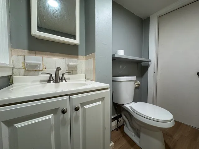a bathroom with a granite countertop toilet sink and mirror