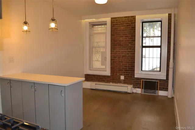a view of an empty room with window and cabinet