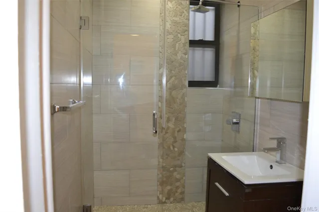 a bathroom with a sink shower and a mirror