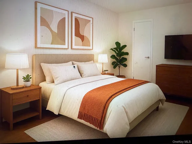 a bedroom with a bed and a flat tv screen on dresser