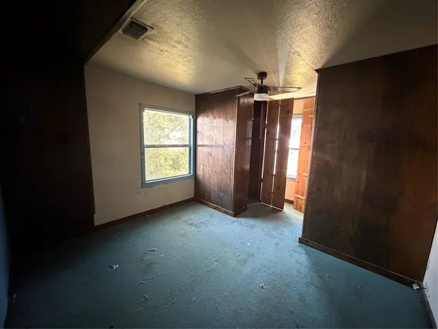 an empty room with windows and closet