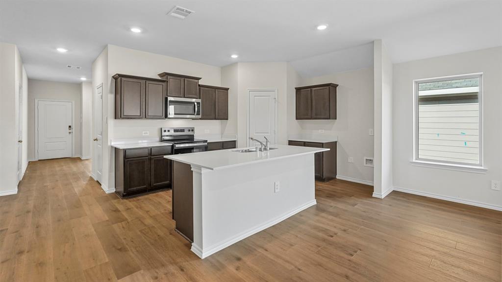 1953 Freeman Street Tyler, TX 75704 - Photo 3 of 32 Open-concept kitchen featuring dark wood cabinetry, white countertops, and stainless steel appliances