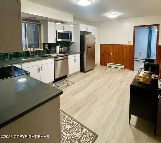 a kitchen with stainless steel appliances a refrigerator sink and microwave