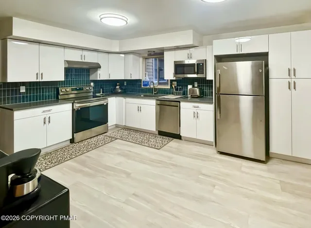 a kitchen with a refrigerator stove top oven and sink