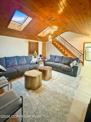 a living room with furniture and a dining table with wooden floor