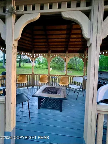 a view of patio with table and chairs potted plants with wooden floor and fence