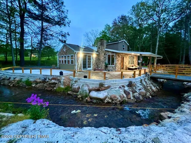 a front view of a house with a garden and outdoor seating