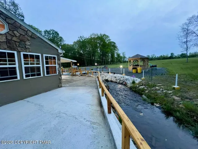 a view of a house with backyard and sitting area