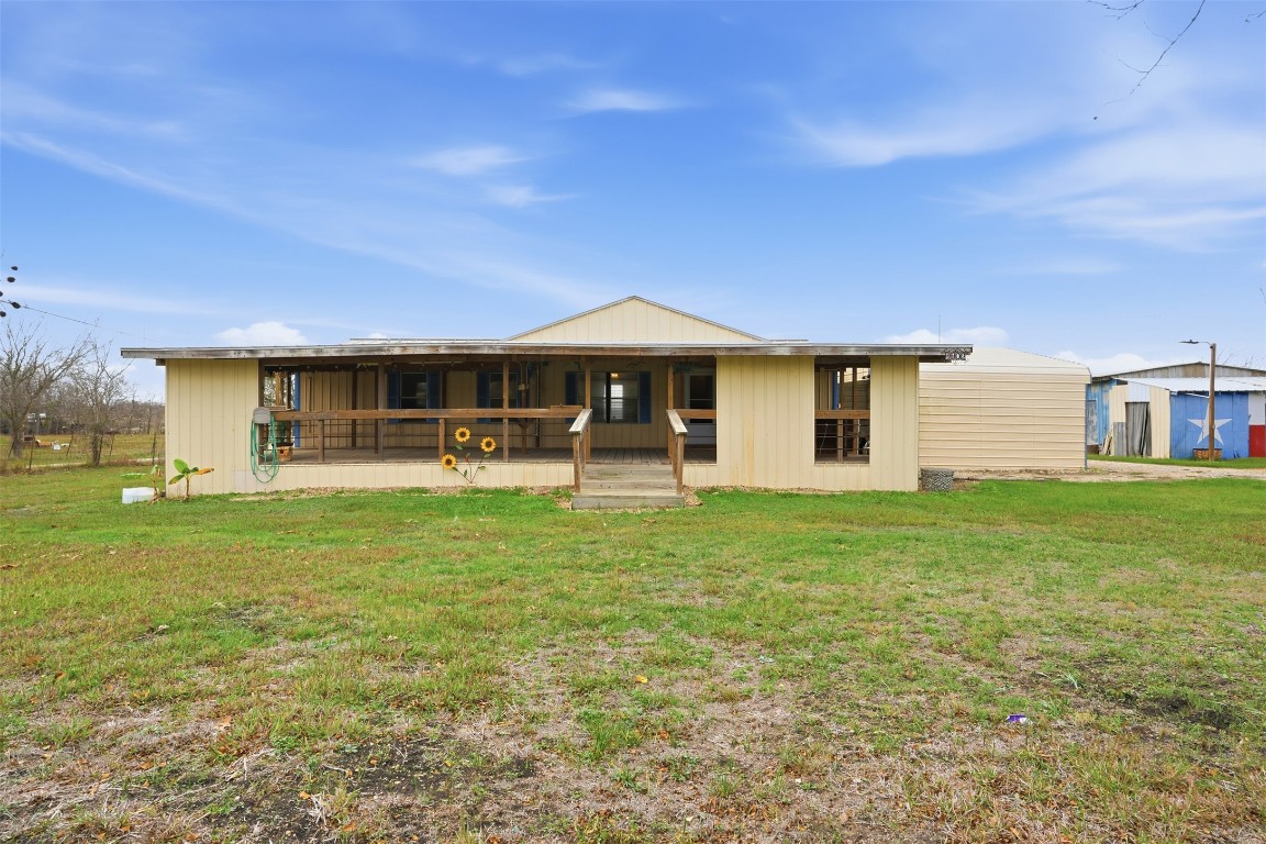 Back of house featuring a yard and a porch