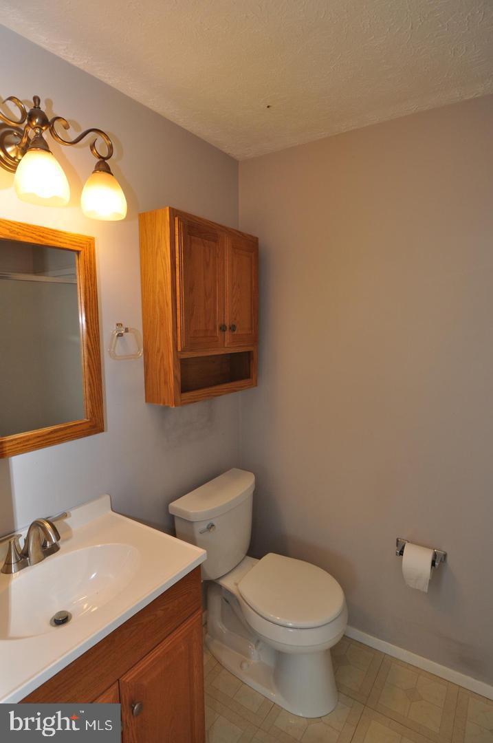 19609 Gunners Branch Road, Unit F Germantown, MD 20876 - Photo 13 of 18 a bathroom with a sink a toilet and mirror