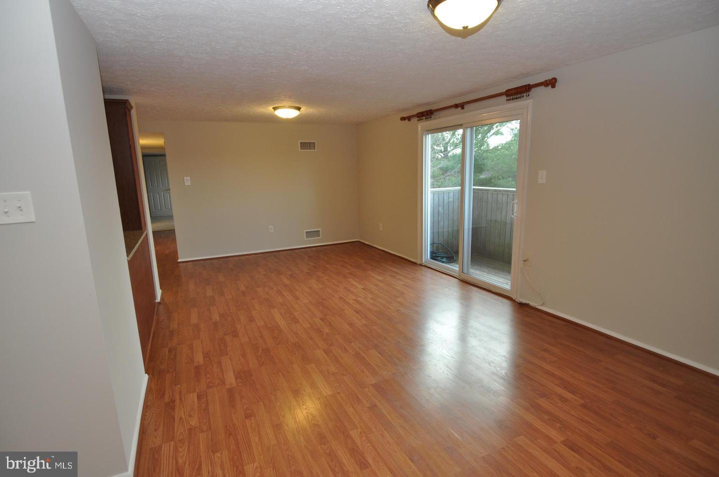19609 Gunners Branch Road, Unit F Germantown, MD 20876 - Photo 8 of 18 an empty room with wooden floor and windows