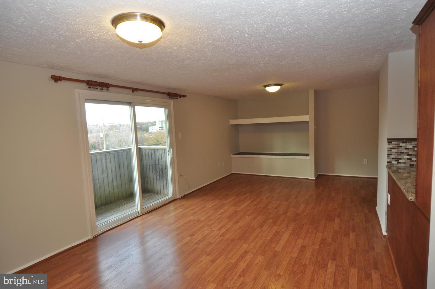 19609 Gunners Branch Road, Unit F Germantown, MD 20876 - Photo 9 of 18 an empty room with wooden floor and windows