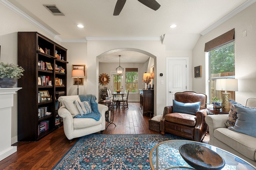 6708 Menchaca Road, Unit 2 Austin, TX 78745 - Photo 3 of 30 Living area featuring wood-finish flooring, a built-in bookshelf, crown molding, an arched doorway, and recessed lighting
