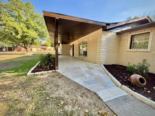 a view of a house with backyard and trees