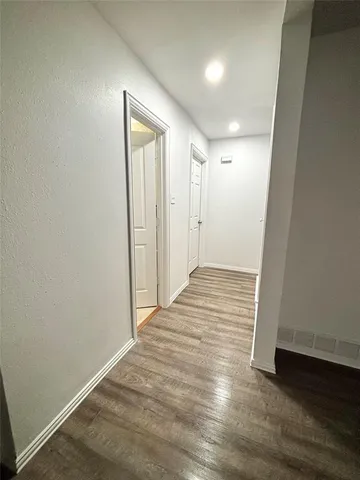 a view of an empty room with wooden floor