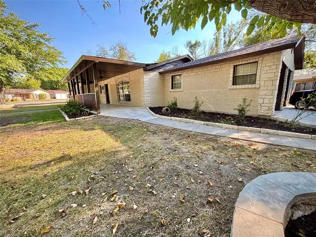 a view of a house with backyard and trees
