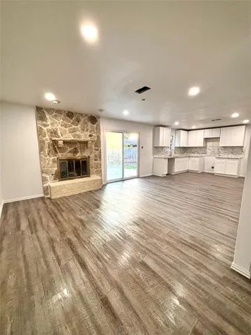 an empty room with windows and ceiling fan