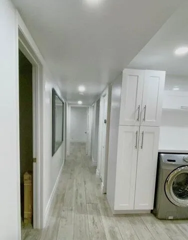 a view of a hallway with a washer and dryer