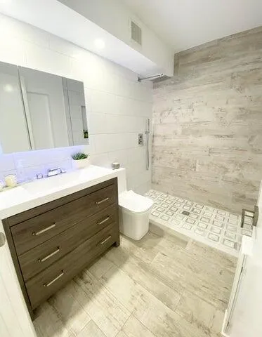 a bathroom with a sink mirror and a toilet