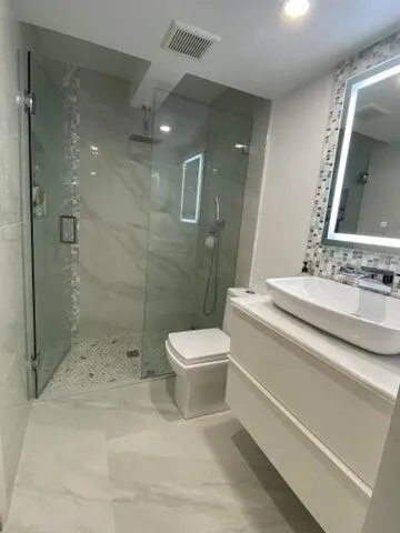 a bathroom with a sink a toilet and shower