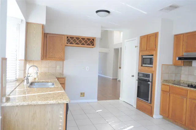 a kitchen with stainless steel appliances granite countertop a sink and a refrigerator